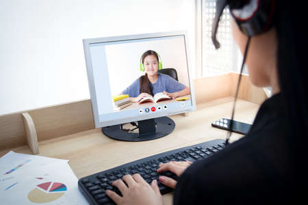 Female teacher teaches students from home By using a laptop computer via online video call. The concept of distance education over the internet during the Covid19 periodの写真素材