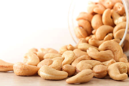 Cashew nuts in glass bottles Placed on a wooden floor. Food photography concept. Copy space
