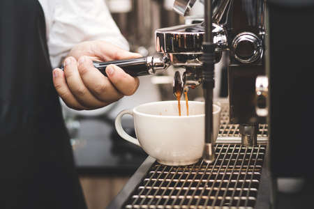 Close up of Extraction of coffee from the machine. Service concept of Barista Cafe in his shop.の写真素材