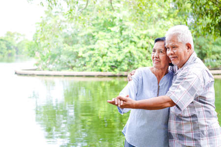 Elderly lovers holding hands dancing in the garden Have fun in retirement life. Senior community conceptsの写真素材