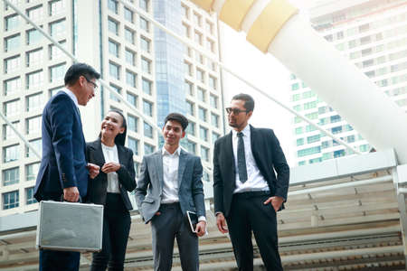 Asian office workers wearing a suit stand talking about doing business investment.の写真素材
