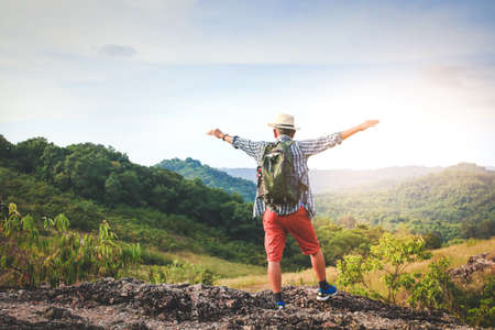 An old man carrying a backpack, hiking and standing on a high mountain He is happy. Senior travel conceptの写真素材