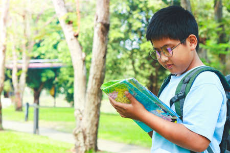 Asian male students Carrying a travel backpack, holding a map to travel to learnの写真素材