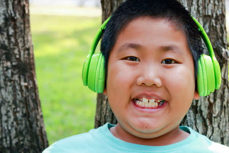 Fat Asian boy wears green music headphonesの写真素材