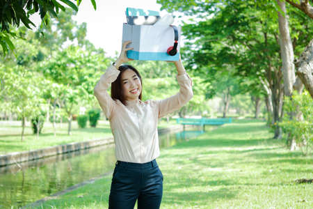 Office girl holding a white paper box, put files and music headphones Happy smileの写真素材