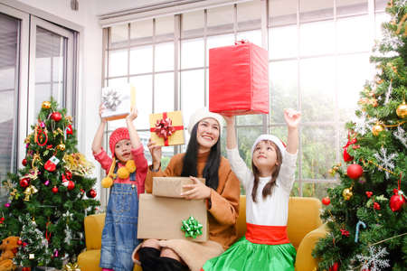 Two cute girls are happy that Beautiful sisters give presents at Christmas. They are happy on the...