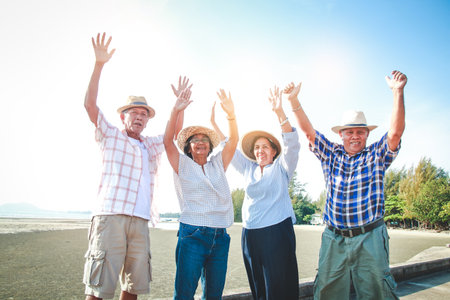 The elderly group of men and women in Asia visited the sea. Lift both arms with pleasure.  Elderly community concept. take care of your healthの写真素材