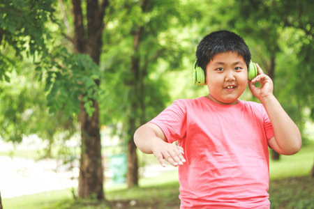 Asian children wear headphones, green music, fun with music in the garden.の写真素材