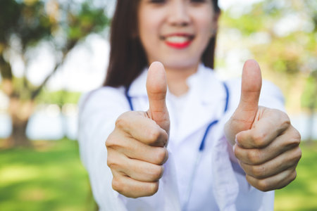 Beautiful young doctor, thumbs up, likes to maintain healthの写真素材