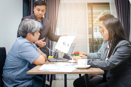 Male and female business groups sitting in the office of the manager are presenting work.の写真素材