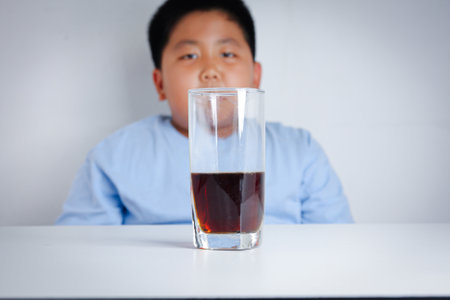 Fat children drink very soft drinks, not good for health.の写真素材
