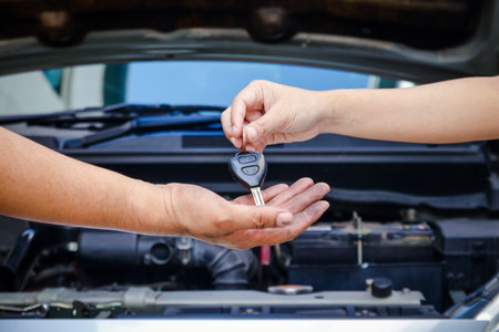 The woman's hand, the owner of the car, gave the keys to the mechanic to repair it.の写真素材