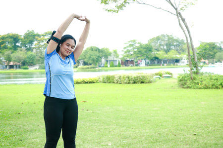 Fat women stand to exercise in the garden to make the body healthy.の写真素材
