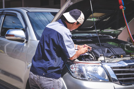 The car mechanic is checking the engine system.の写真素材