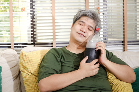 Older obese men are happy to drink soft drinks. Concept of obesity and health problemsの写真素材