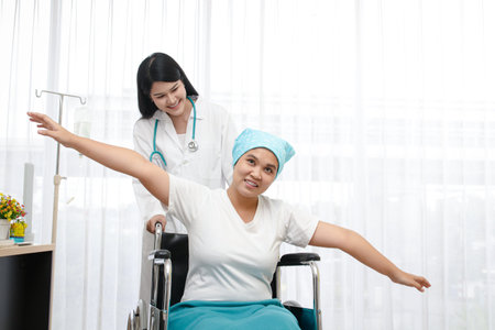 Asian female doctor provided treatment for patients sitting in a wheelchair, taking care closely. Cancer treatment hospital concept, health insurance.copy spaceの写真素材