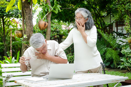 Asian elderly man Sitting and working in the garden He is sick The wife was shocked and rushed to take care of it. Senior health care conceptの写真素材