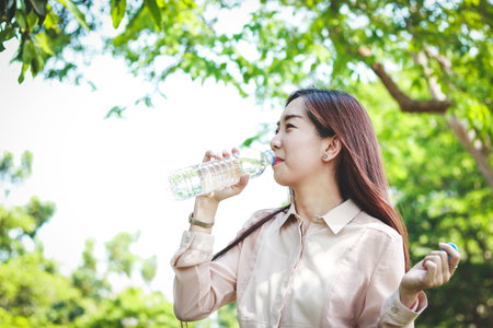 Working women are drinking clean water. It makes her body refreshed.の写真素材