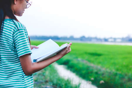 Asian children open a white book to study and learn.の写真素材
