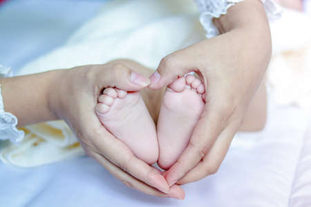 Mother caught baby's feet, made a heart-shaped handの写真素材