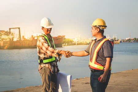 Engineers and technicians wear safety hats Standing hand in hand to make the job successful
