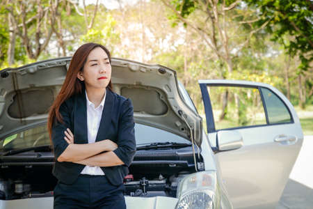 The girl lost the car, waiting for help. She was stressed about how to travel.の写真素材