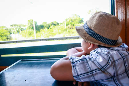 Asian boy sitting on a train to travel