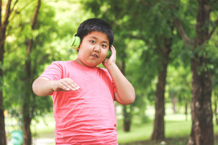 Boys wearing green headphones Happy smile in the natural garden. Concept of educationの写真素材
