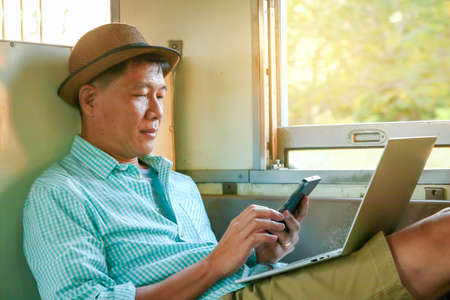Men traveling by train Open notebook computers, send information to customersの写真素材