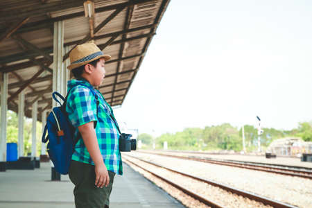 Asian boy standing holding a camera Travel by trainの写真素材