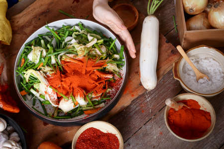 Korean women preparing to make kimchi, carrying a cup of fresh vegetables consisting of Radishes, Chinese cabbage, carrots, apples, onions, garlic. Fermented cooking.の写真素材