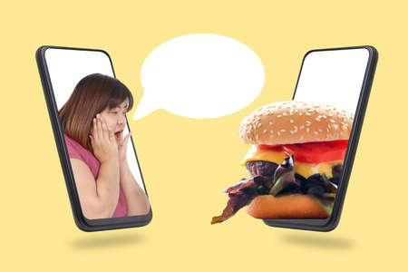 Fat woman on black smartphone touch screen She wanted to eat the hamburger that was on the phone. Concept of technology selling products online via internet Home delivery. Clipping Pathの写真素材
