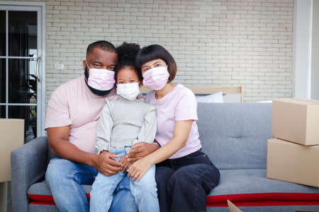 African American family moves into a new home, sitting on the sofa in the living room. . Concept of mixed race family. Copy spaceの写真素材
