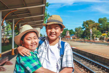 Two boys travel to stand and wait for the train at Lopburi Station, Thailand.の写真素材