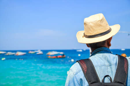 An elderly Asian man wearing a hat on the beachの写真素材