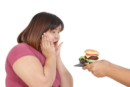 Fat Asian woman wearing exercise clothes to lose weight, happy posture, someone gave her hamburger. Concept of health problems of obese people. White backgroundの写真素材