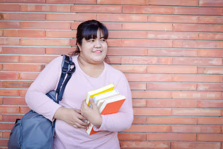 Asian woman carrying a textbook and carrying a bag. Concept of adult education Personal development...