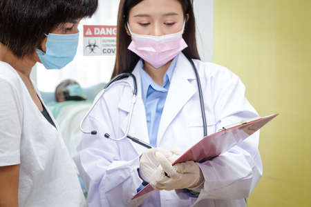 An Asian female doctor explains to his wife the treatment information of an African-American male...