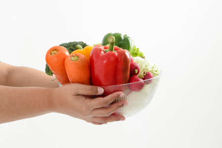 Fat woman holding a bowl of fresh organic vegetables Food for good health. The concept of losing weight, reducing fat Healthy eating, nutrition, prescription food. White backgroundの写真素材