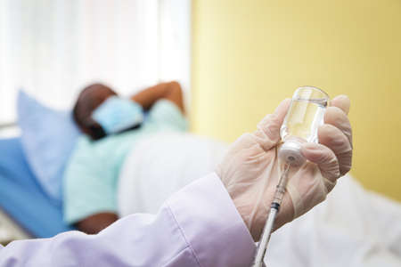 Doctors wear gloves to vaccinate African-American menの写真素材