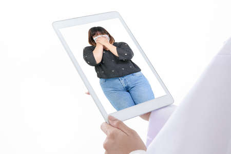 Online medical concept. Doctors hold a tablet to connect to talk long distance with obese patients via video call. Social distance, hospital medical services. White backgroundの写真素材