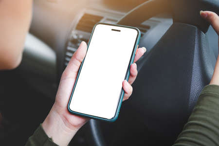 woman holding a white touch screen smartphone Call an insurance company or a mechanic for help. Because she was in an accident or the car engine broke down. Car insurance, communication technologyの写真素材