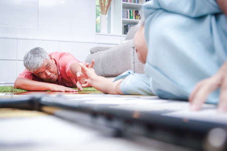 concept of elderly people who are sick fell on the ground unable to walk Couples hold hands and get up. Caring for and maintaining the health of the elderly retiredの写真素材