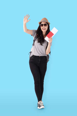 beautiful asian woman wear a mask and holding a passport to travel abroad Standing on a blue background. travel concept. Clipping Pathの写真素材