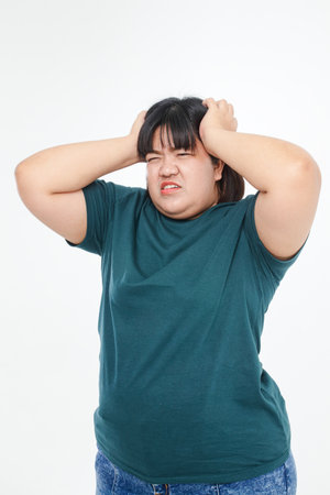 Fat Asian women are overweight. have a headache Use your hands to press against your head to reduce pain. Health problems of obese people. white backgroundの写真素材