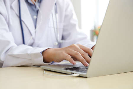 Asian female doctor online video call Check the symptoms with the patient via the Internet. on a...