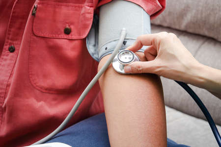 A nurse measures the blood pressure to an elderly man. who stay at home concept of health care,...