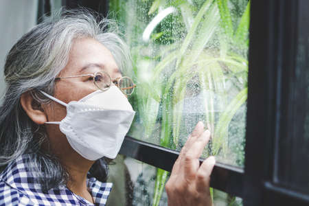 Asian elderly woman Stay at home to prevent infection. During the virus epidemic She looked at the...