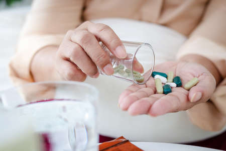 Asian elderly woman stay home to prevent infection During the coronavirus epidemic She was sick with a fever and took medication to treat the virus. Home isolation concept, stay at homeの写真素材
