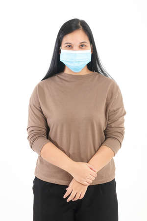asian fat woman wearing a blue mask stand on a white background. Concept of health care during the coronavirus pandemic, prevention, social distancing. isolatedの写真素材